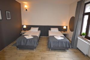 a room with two beds and two tables at SleepWell Apartments in Legnica