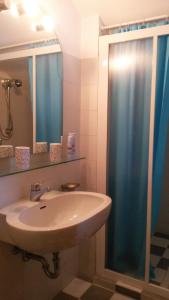 波爾托瓦爾特拉瓦利亞的住宿－Golfo Aranci，浴室设有水槽和蓝色的浴帘