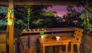 - une table et un banc en bois sur un balcon la nuit dans l'établissement Colibri hostal Minca Santa Marta, à Minca