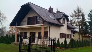 a large white house with a black roof at DobraNocka in Kaleń