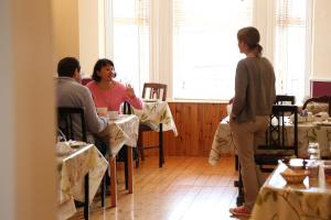 grupa ludzi siedzących przy stolikach w pokoju w obiekcie An Caislean Guest House w mieście Ballycastle