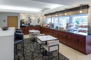 a restaurant with tables and chairs and a counter at Wingate by Wyndham Shreveport Airport in Shreveport