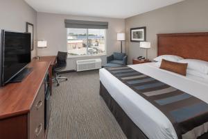 a hotel room with a large bed and a flat screen tv at Wingate by Wyndham Shreveport Airport in Shreveport