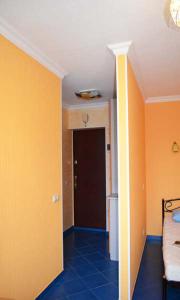 キーウにあるApartment Laboratorniy per. 26のオレンジ色の壁の客室とベッド付きの廊下が備わります。