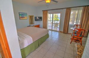 a bedroom with a bed and a table and chairs at Coco La Palm in Negril