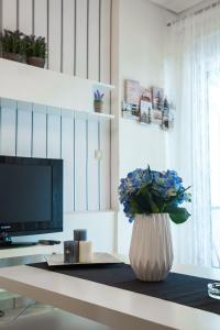 een vaas met blauwe bloemen op een tafel in een woonkamer bij Luxury City Center Apartment in Kalabaka