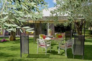 - une table et des chaises sous un kiosque dans une cour dans l'établissement Isabella Country House, à Gouviá