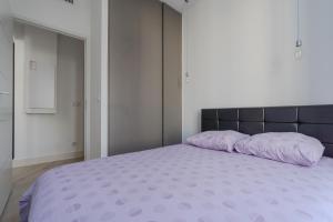 a bedroom with a large bed with purple pillows at Carré d'OR! Park view! in Nice