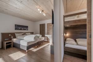two beds in a bedroom with wooden ceilings at Berghotel & Gasthof Marlstein in Oetz
