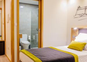 a bedroom with a bed and a bathroom with a shower at Venceslau Boutique in Vila do Conde +48 photos