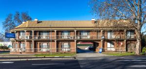 um grande edifício de tijolos com uma varanda na frente em Albury Townhouse Motel em Albury