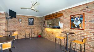 a bar with stools and a picture of a dog on the wall at Rest Point Motor Inn in Glen Innes