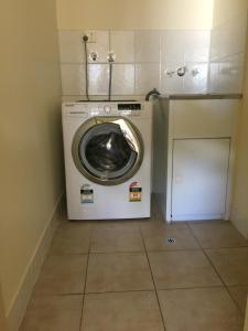 - Lavadora y secadora en una habitación pequeña en Cairns Golf Course Apartment, en Cairns