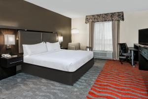 um quarto de hotel com uma cama grande e uma secretária em Holiday Inn & Suites College Station-Aggieland, an IHG Hotel em College Station