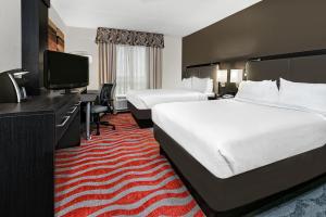 um quarto de hotel com duas camas e uma televisão de ecrã plano em Holiday Inn & Suites College Station-Aggieland, an IHG Hotel em College Station