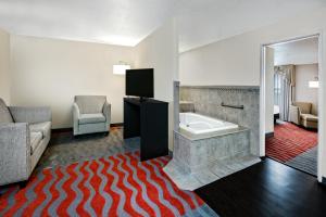 um quarto de hotel com uma banheira e uma sala de estar em Holiday Inn & Suites College Station-Aggieland, an IHG Hotel em College Station