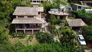 eine Luftansicht eines Hauses mit einem davor geparkt in der Unterkunft Pousada e Hostel Vale do Rosa in Praia do Rosa