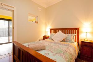 a bedroom with a bed with two lamps and a window at Taree Apartment in Taree
