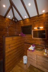 a wooden bathroom with a sink and a tub at Le matelot de la baie in Deshaies