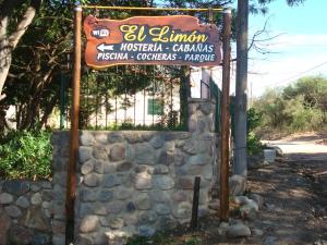 een bord voor een restaurant naast een stenen muur bij El Limon in San Marcos Sierras
