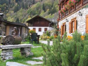 a garden with a bench in front of a building at Baita Reale in Alagna Valsesia
