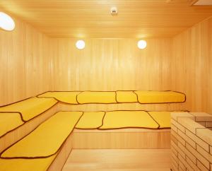 a sauna with three beds in a wooden room at SPA&HOTEL RESORT Furano La Terre in Nakafurano