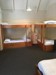 a room with three bunk beds in a room at Avondale Motor Park in Auckland