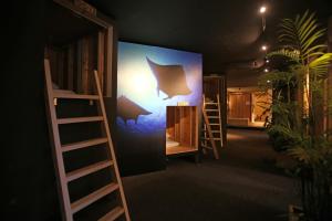 a room with bunk beds and a wall with a painting of a bat at Guest House Chura Cucule Ishigakijima in Ishigaki Island