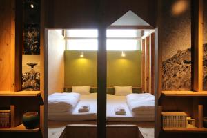 石垣島にあるゲストハウスちゅらククル石垣島の窓付きの部屋にベッド付きのベッドルーム1室があります。