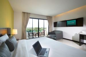 a hotel room with a laptop on a bed at Simplitel in Karon Beach