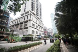 Un edificio en una calle de la ciudad con una persona conduciendo una motocicleta. en Soho Suites @ KLCC by Luxury Suites Asia, en Kuala Lumpur