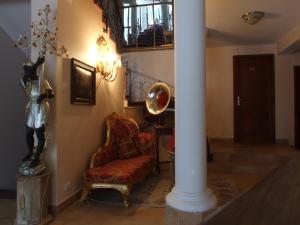 a living room with a chair and a mirror at Hotel Royal in Zalău