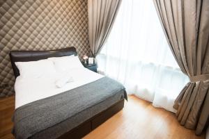 a bedroom with a bed and a large window at Soho Suites @ KLCC by Luxury Suites Asia in Kuala Lumpur