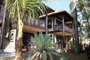 una casa con delle palme davanti di Lotus Village Resort a Mui Ne