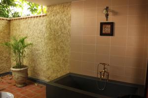 un bagno con una vasca con una pianta dentro di Lotus Village Resort a Mui Ne