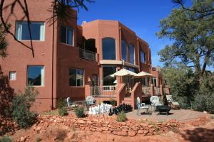 a building with chairs and umbrellas in front of it at Sedona Cathedral Hideaway B&B & Spa in Sedona
