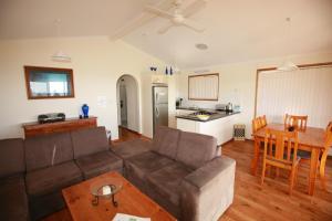uma sala de estar com um sofá e uma mesa em Waves & Wildlife Cottages Kangaroo Island em Stokes Bay