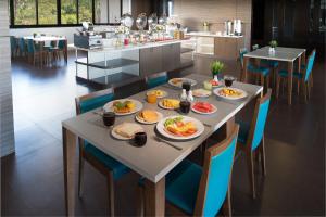 a table with plates of food on it in a kitchen at Simplitel in Karon Beach