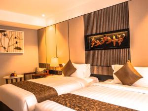 سرير أو أسرّة في غرفة في The Nest Hotel Nusa Dua