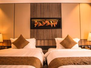 سرير أو أسرّة في غرفة في The Nest Hotel Nusa Dua