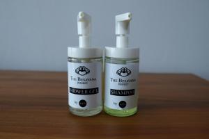 two bottles of sunscreen sitting on a wooden table at The Besavana Phuket - SHA Extra Plus in Phuket Town
