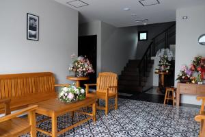a waiting room with benches and flowers and stairs at The Besavana Phuket - SHA Extra Plus in Phuket Town