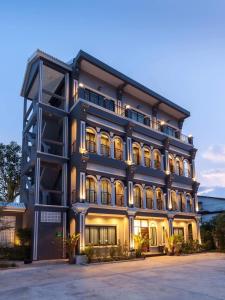 a large building with lights in front of it at The Besavana Phuket - SHA Extra Plus in Phuket Town