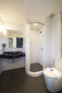 a bathroom with a shower and a toilet and a sink at Simplitel in Karon Beach