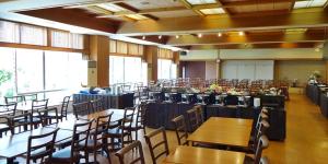 einen Bankettsaal mit Tischen, Stühlen und Fenstern in der Unterkunft Itoen Hotel in Ito