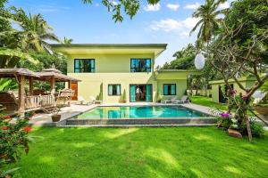 a backyard with a swimming pool and a house at Baan Suaan Serenity in Laem Sor