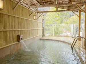 a swimming pool with a water fountain at Itoen Hotel Hakone Yumoto in Hakone