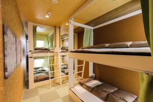a room with two bunk beds and a mirror at Kobe Nadeshikoya in Kobe