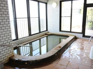 una piscina de agua en una habitación con ventanas en Kindayu, en Shibukawa