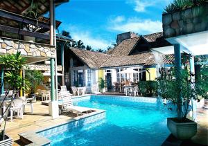 a swimming pool in front of a house at Pousada Vitória in Ilhéus